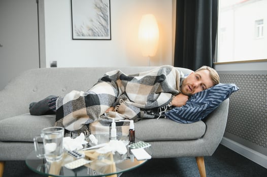 Sick man lying on sofa at home. photo