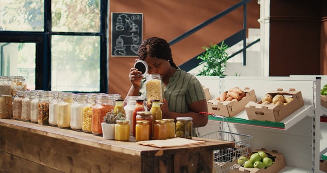 Vegan buyer looking at pasta types in recyclable jars, examining additives free natural bulk items. Woman shopping for organic bio goods, sustainable lifestyle and healthy nutrition. Handheld shot. photo