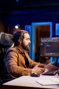 Computer scientist securing company servers from cyberattacks to avoid unwanted failures. IT admin in living room writing code to build firewalls protecting data from threats photo