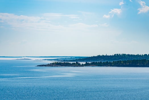 A picturesque forested island surrounded by the pristine blue waters of a tranquil lake. Perfect for nature and travel enthusiasts looking for a serene and natural landscape. photo