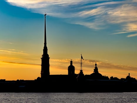 Stunning silhouette of St. Petersburg's skyline at sunset, featuring the Peter and Paul Fortress and other historic landmarks against a vibrant sky photo