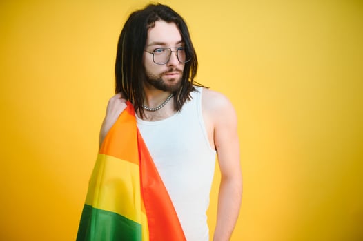 Happy gay man having fun holding rainbow flag symbol of LGBTQ community photo