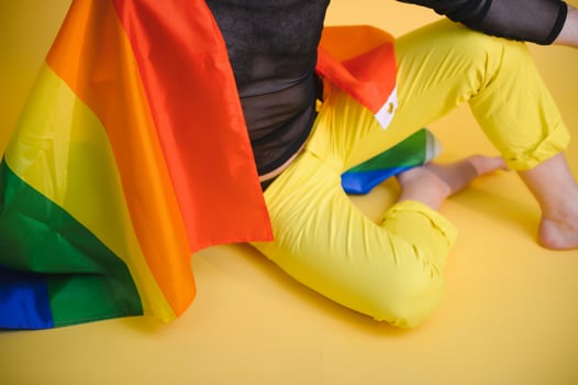 Happy gay man having fun holding rainbow flag symbol of LGBTQ community photo