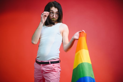 Young gay man is standing in the studio and posing for a camera. photo