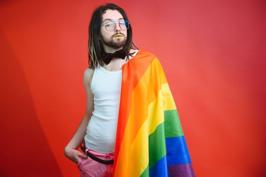 Happy gay man having fun holding rainbow flag symbol of LGBTQ community photo