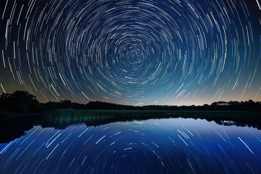 Long Exposure Photo of Star Trail Over Lake Background