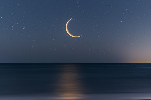 Moon Seen in Sky over Ocean Background photo