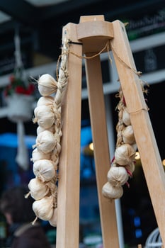 Lake como, Italy-April 26, 2024 Braided Garlic Hanging at Market Stall photo