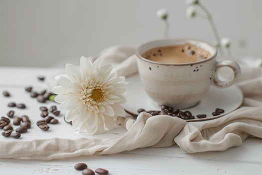 Coffee beans and a white flower on a white table background photo
