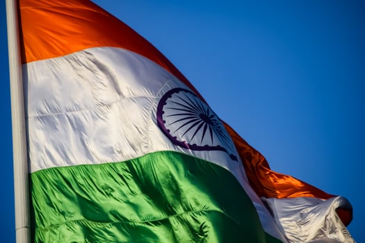 India flag flying high at Connaught Place with pride in blue sky, India flag fluttering, Indian Flag on Independence Day and Republic Day of India, tilt up shot, Waving Indian flag, Har Ghar Tiranga photo
