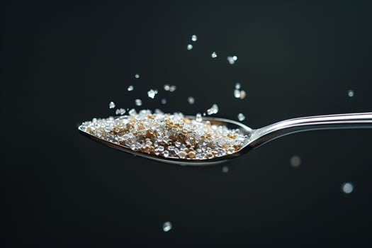 Spoon Full of Sugar Being Poured into a Glass photo