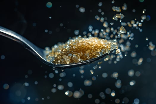 Spoon Full of Sugar Being Poured into a Glass photo