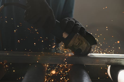 Unrecognizable metal worker grinding metal with an electric saw. photo