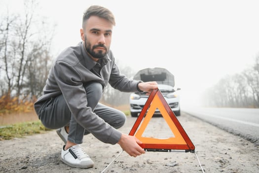 Sad man on the road next to the broken car photo
