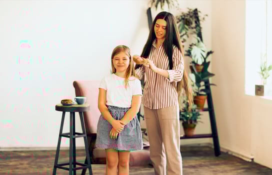 Woman caring about smiling girl at home photo