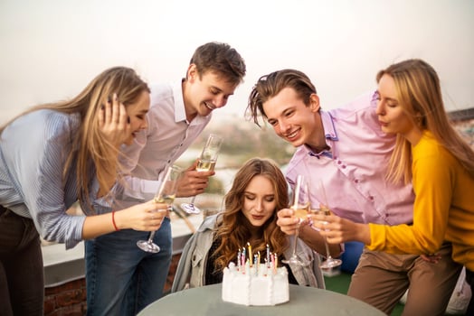 Young blond happy girl blows candles photo