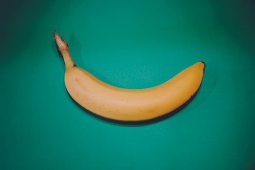 Colorful fruit banana pattern of fresh yellow bananas on blue green background. Vintage style. From top view photo