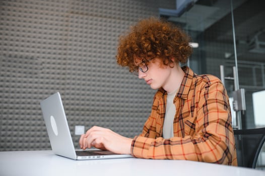 male programmer wear spectacles for eyes protection while working on freelance via laptop computer,clever student watching tutorial on netbook. photo
