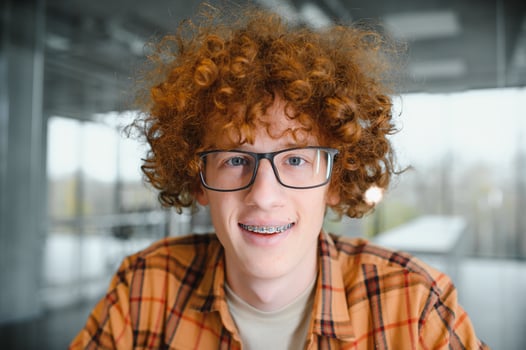 cute red-haired guy wearing stylish glasses yellow t-shirt. photo