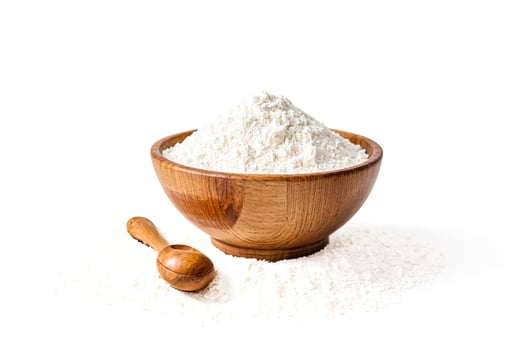 Close Up of Bowl Filled with Flour and Wooden Scoop on White Background photo