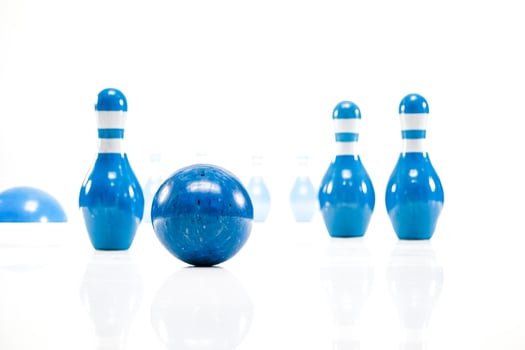 Blue bowling ball and pins on white background photo