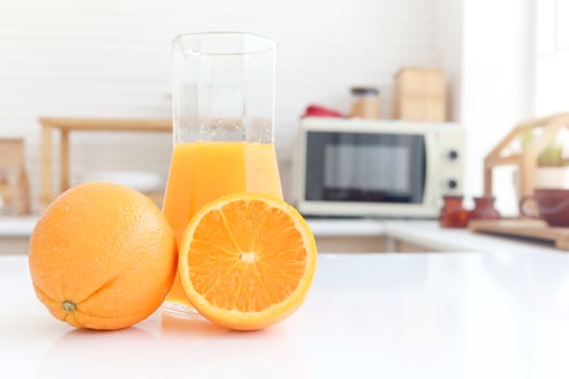 Fresh orange fruit and orange juice in jug on counter at home kitchen. Sweet and tasty fruit with blurred background home kitchen. photo