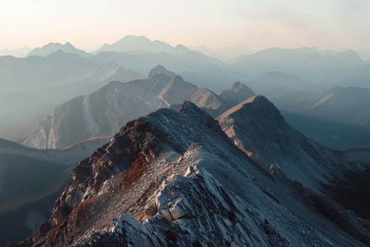 A Mountain Range with a Person Standing on Top with a Scenic Background photo