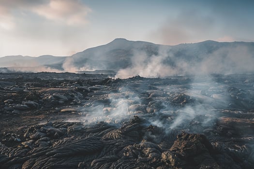 a view of a lava field with smoke coming out of it background photo