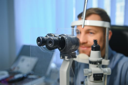 Adult man eyesight test with binocular slit-lamp. Checking retina of a male eye close-up. Ophthalmology Clinic photo