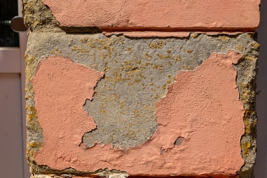 old cracked brick wall with a pink spot on it photo