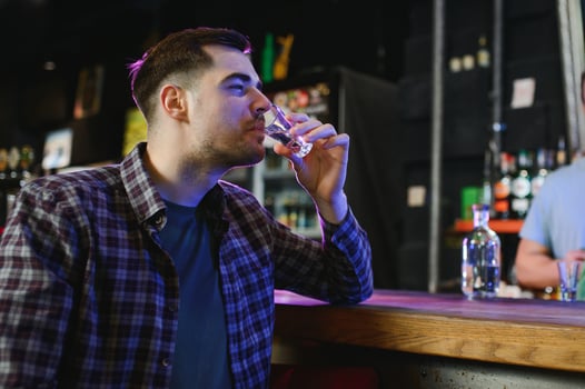 a man drinks vodka at a bar photo
