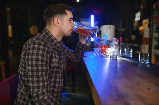 Handsome bearded man drinking beer at the bar counter in pub photo