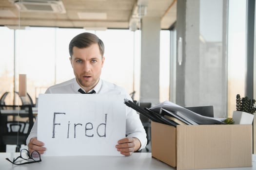 business, firing and job loss concept - fired male office worker with box of his personal stuff. photo