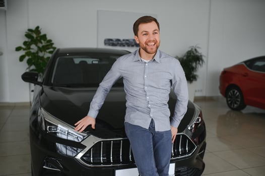 Young man is choosing a new vehicle in car dealership. photo