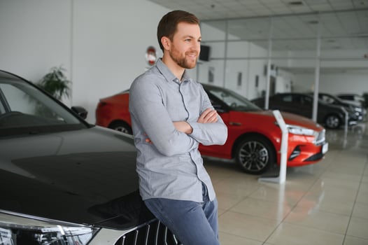 Young man is choosing a new vehicle in car dealership. photo
