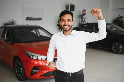 happy indian man buy new biodiesel eco automobile in lux showroom. photo