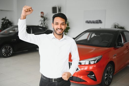 happy indian man buy new biodiesel eco automobile in lux showroom. photo