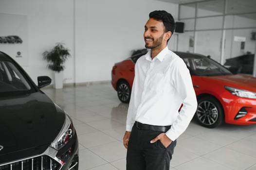 happy indian man buy new biodiesel eco automobile in lux showroom. photo