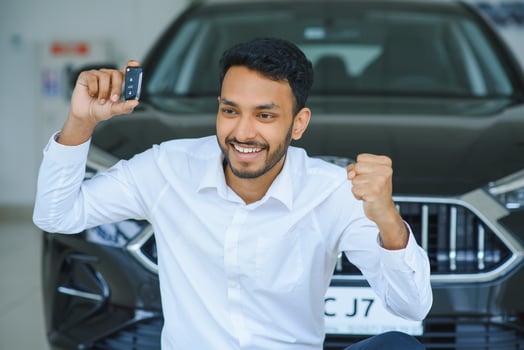 Happy indian man showing the key of his new car photo