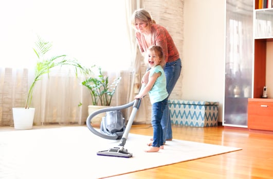 Grandmother and granddaughter cleaning room together photo