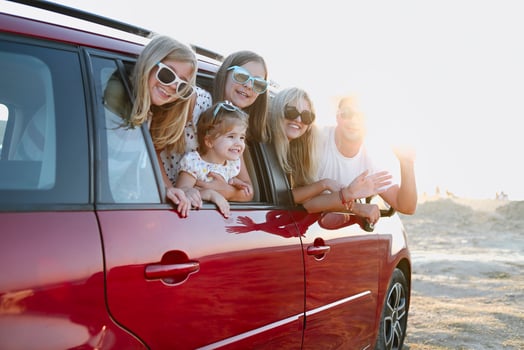 Happy smiling family with daughters in the car with sea background photo