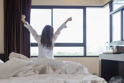 young woman wakes up in morning alone and prepares to go to work. young woman prepares to put on her clothes after waking up in morning to prepare to go on an excursion according to program. photo