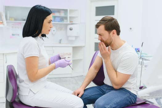 Woman dental doctor. dentist shows model of Jaws. Visual aid for training orthodontists. Sample Jaws for teaching dentists. Blurred woman dentist teaches to look after teeth. Dental health. photo