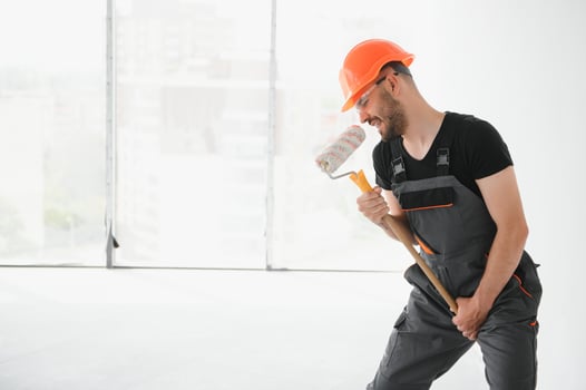 Funny and cheerful worker sings in a roller for painting the walls photo