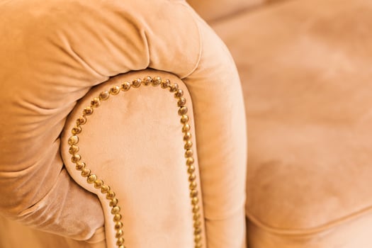 Close-Up of Beige Sofa Armrest with Golden Studs and Warm Evening Light photo