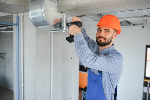 hvac worker install ducted pipe system for ventilation and air conditioning. copy space photo