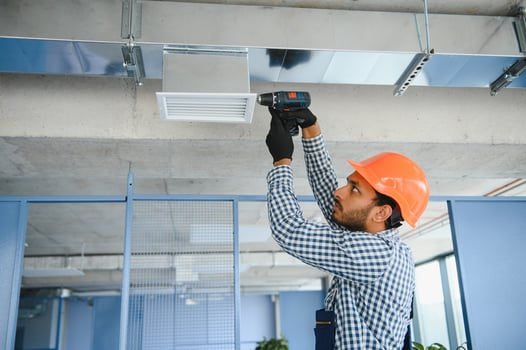 hvac services - indian worker install ducted pipe system for ventilation and air conditioning in house photo