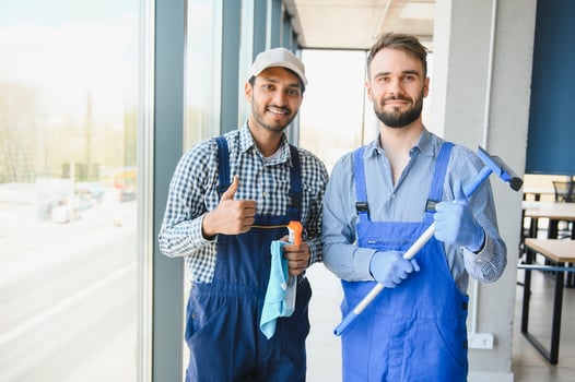 multiethnic professional cleaners in uniform washing large windows in office photo