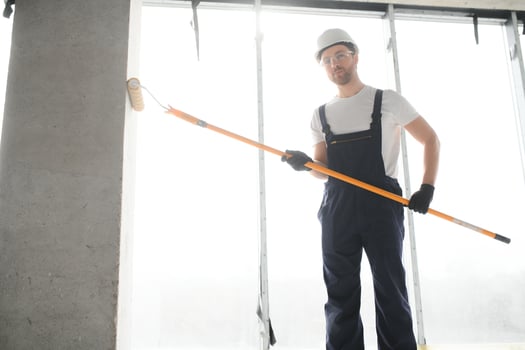 Worker renewing apartment on wall background. photo