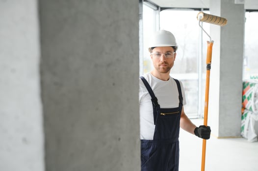 Worker renewing apartment on wall background. photo